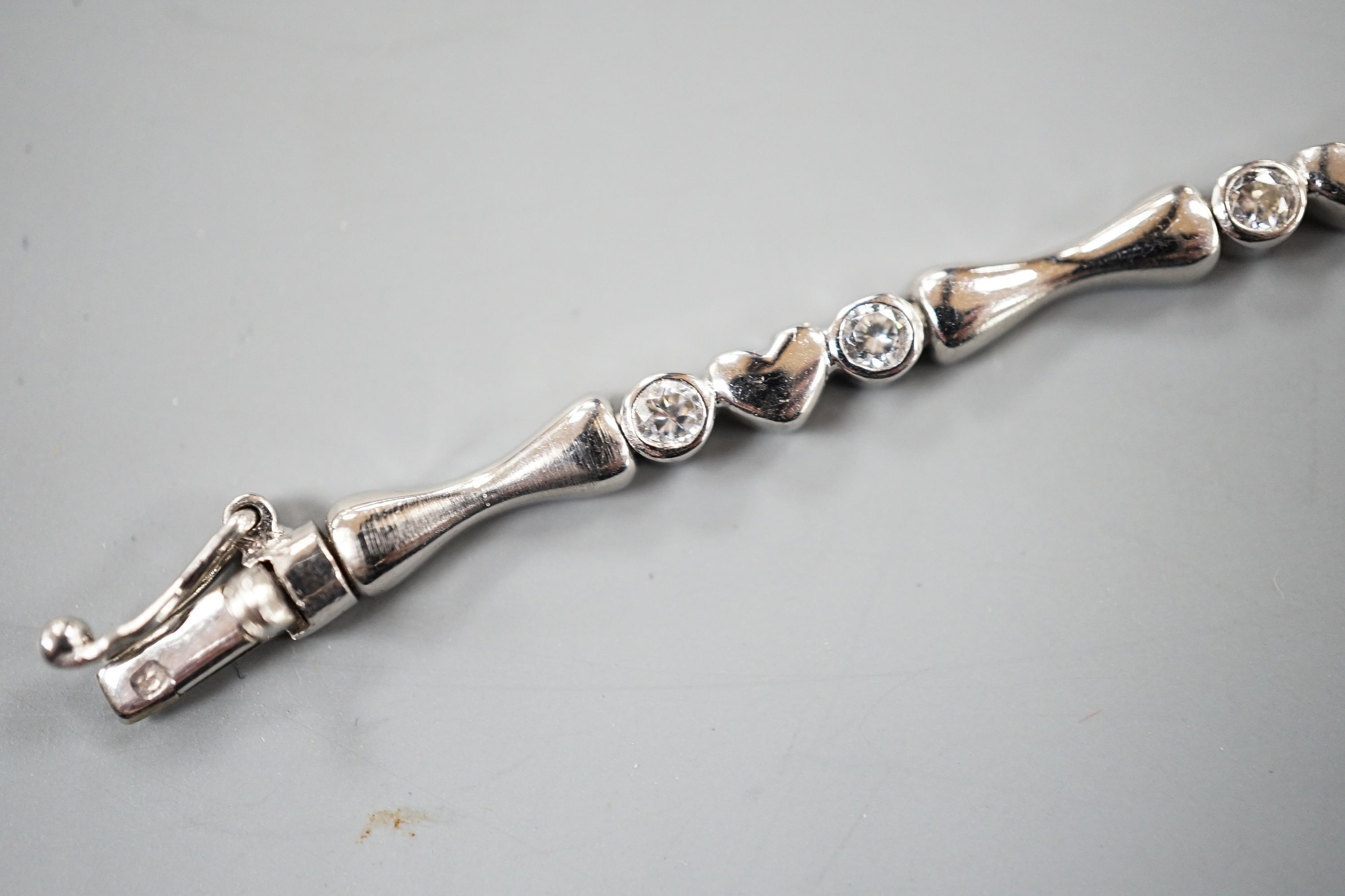 A modern 750 white metal and sixteen stone diamond set line bracelet, 19.2cm, gross weight 12.9 grams.
